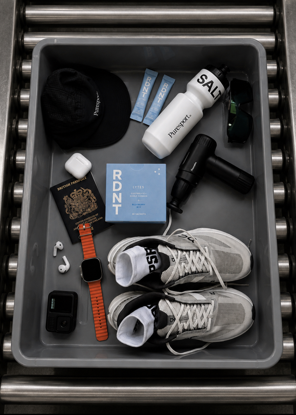 RDNT LYTES Blueberry box in a travel tray with running shoes, water bottle, passport, and headphones